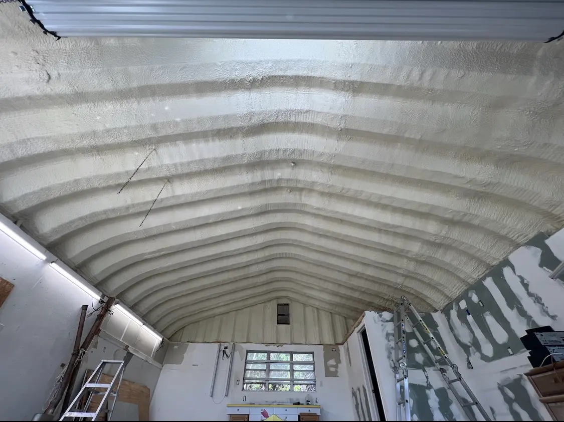 Spray polyurethane foam applied to the underside of a metal roof deck in Adel
